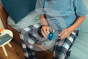 Senior Man Sitting On Bed Taking Medication, close up