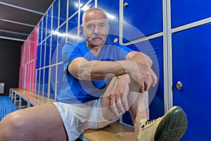 Senior man sitting in gym lockerroom