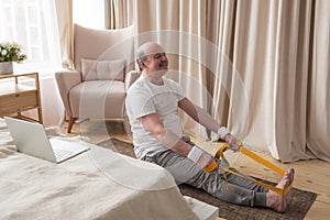 Senior man sitting in paschimottanasana or Intense Dorsal Stretch pose