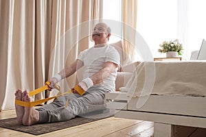 Senior man sitting in paschimottanasana or Intense Dorsal Stretch pose