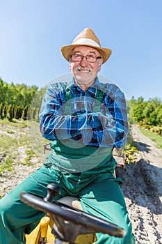 Senior man sitting proud in his tractor after cultivating his farm