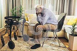 Senior Man Sitting On Sofa At Home Suffering From Depression