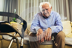 Senior Man Sitting On Sofa Suffering From Depression