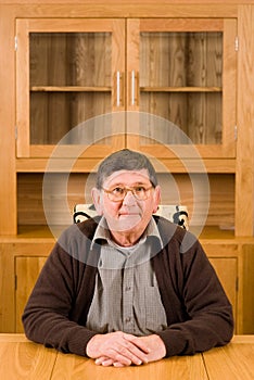 Senior man sitting at table with copyspace above