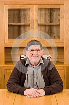 Senior man sitting at table with copyspace above