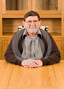 Senior man sitting at table with copyspace below