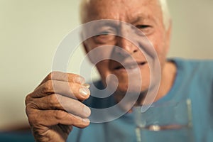 Senior man sitting taking medication