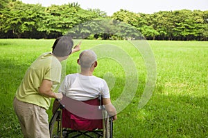 Senior man sitting on a wheelchair with his wife