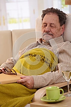 Senior man sleeping in armchair
