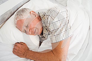 Senior man sleeping on bed