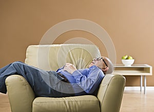 Senior man sleeping on chair.