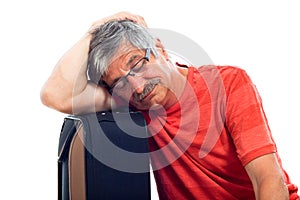 Senior man sleeping on luggage