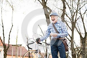 Senior man with smartphone and bicycle in town.