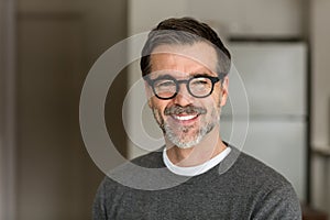 Senior Man Smiling At The Camera. In the kitchen