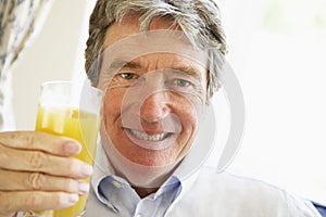 Senior Man Smiling And Drinking Orange Juice