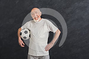 Senior man with soccer ball showing thumb up