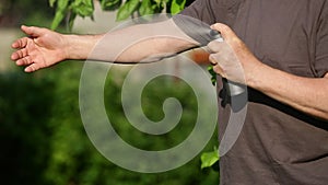 Senior man spraying repellent against kind of insects, mosquitoes and ticks, protection against kind of diseases