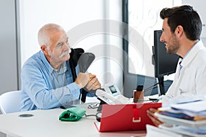 Senior man stand talking to doctor in office