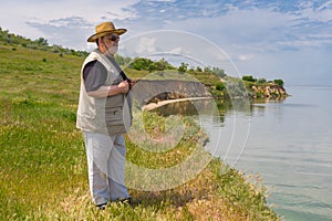 Senior man standing on abrupt riverside of the Dnepr river, Ukraine