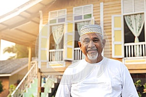 Senior man standing in front of wooden house
