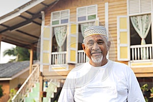 Senior man standing in front of wooden house