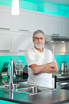 Senior man standing in his modern kitchen