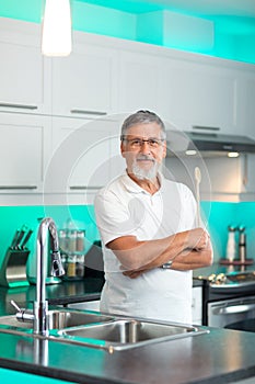 Senior man standing in modern kitchen