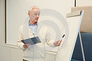 Senior Man Standing by Whiteboard in Office