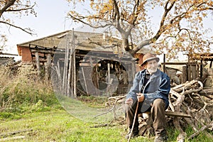 Senior man with stick sitting outdoors