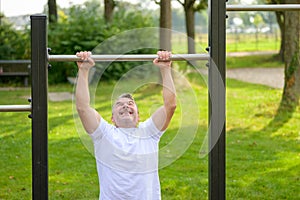 Senior man straining to pull himself up by the arms photo