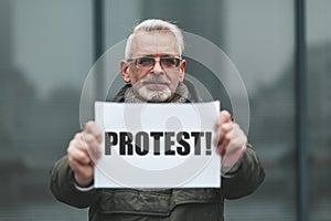 Senior man strike in the street. A mature man\'s protest. A single picket with a banner for your rights