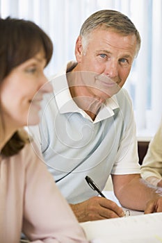 Senior man studying with other students