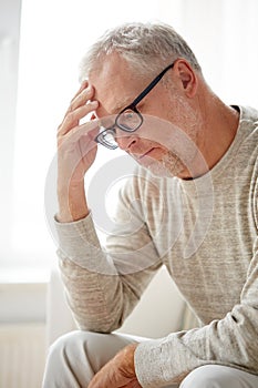 Senior man suffering from headache at home