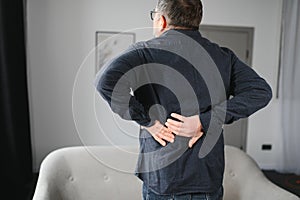 Senior man is suffering from pain in lower back at home