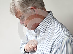 Senior man suffers from bad heartburn