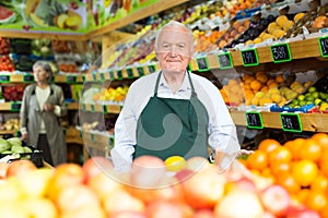 Senior man supermarket worker standing in salesroom