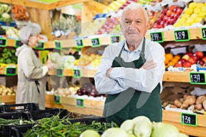 Senior man supermarket worker standing in salesroom