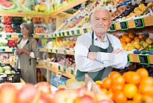 Senior man supermarket worker standing in salesroom