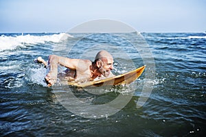 A senior man on a surfboard