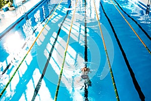 Senior man swimming in an indoor swimming pool.