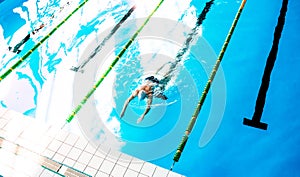 Senior man swimming in an indoor swimming pool.