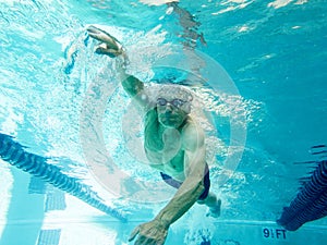 Senior man swimming laps, underwater view