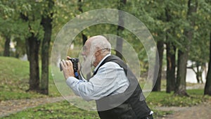 Senior man takes a photo of nature in park