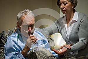 Senior man taking medication with water