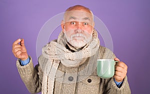 Senior man taking medicine pills with cup of water in hand. Ill man take pill. Elderly man using supplement or vitamin