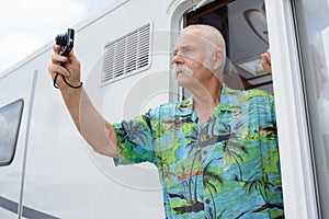 Senior man taking photograph with camera on beach