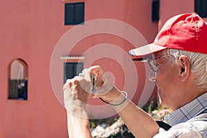 Senior man taking photos with compact camera