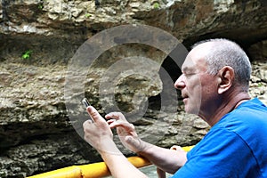 Senior man taking picture in Khadzhokh gorge in summer