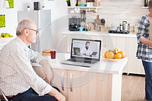 Senior man talking with doctor on video call