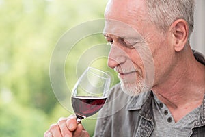 Mature man tasting red wine